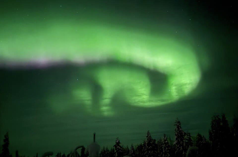 Green aurora swirl in the night sky